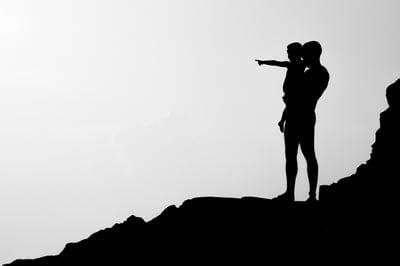 Silhouette of father and child looking at horizon
