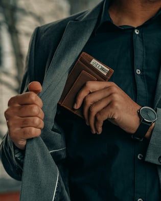 Man stashing wallet in blazer inner pocket