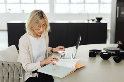 Woman reviewing text and laptop