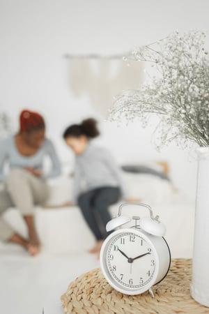 Clock in foreground, with family in background