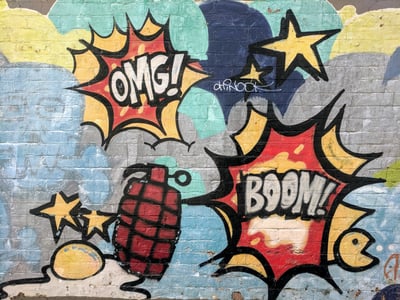 Graffiti with stars and grenades, saying "OMG!" and "Boom!"